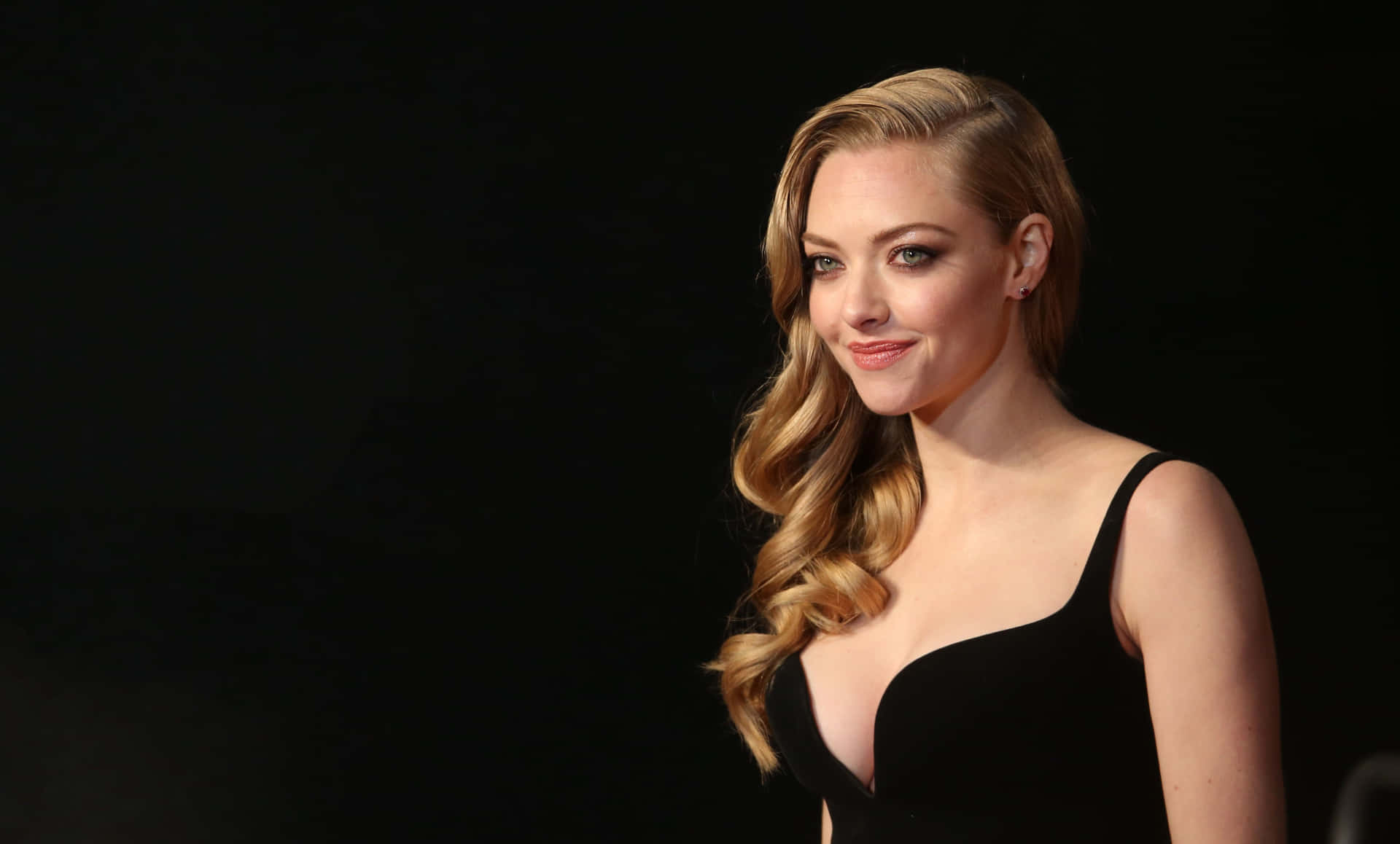 A Woman In A Black Dress Posing For The Camera Background