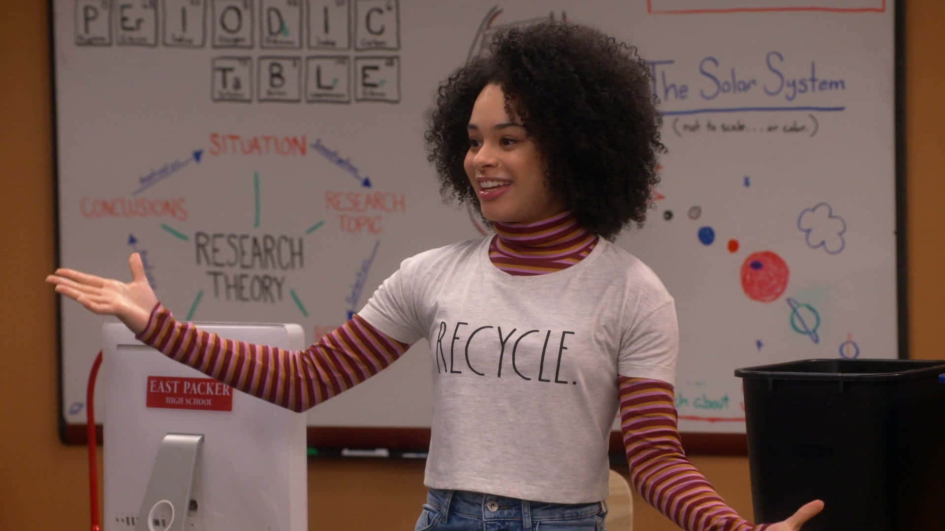 A Woman In A Green Shirt Standing In Front Of A Whiteboard Background