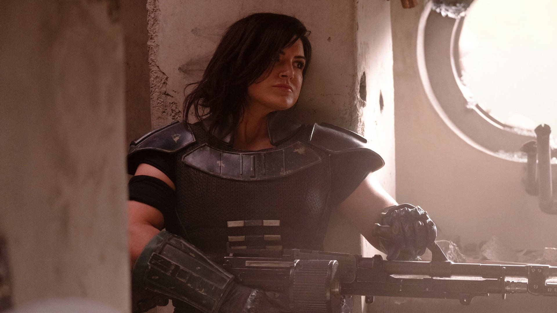 A Woman In A Helmet And Armor Is Standing In A Room Background