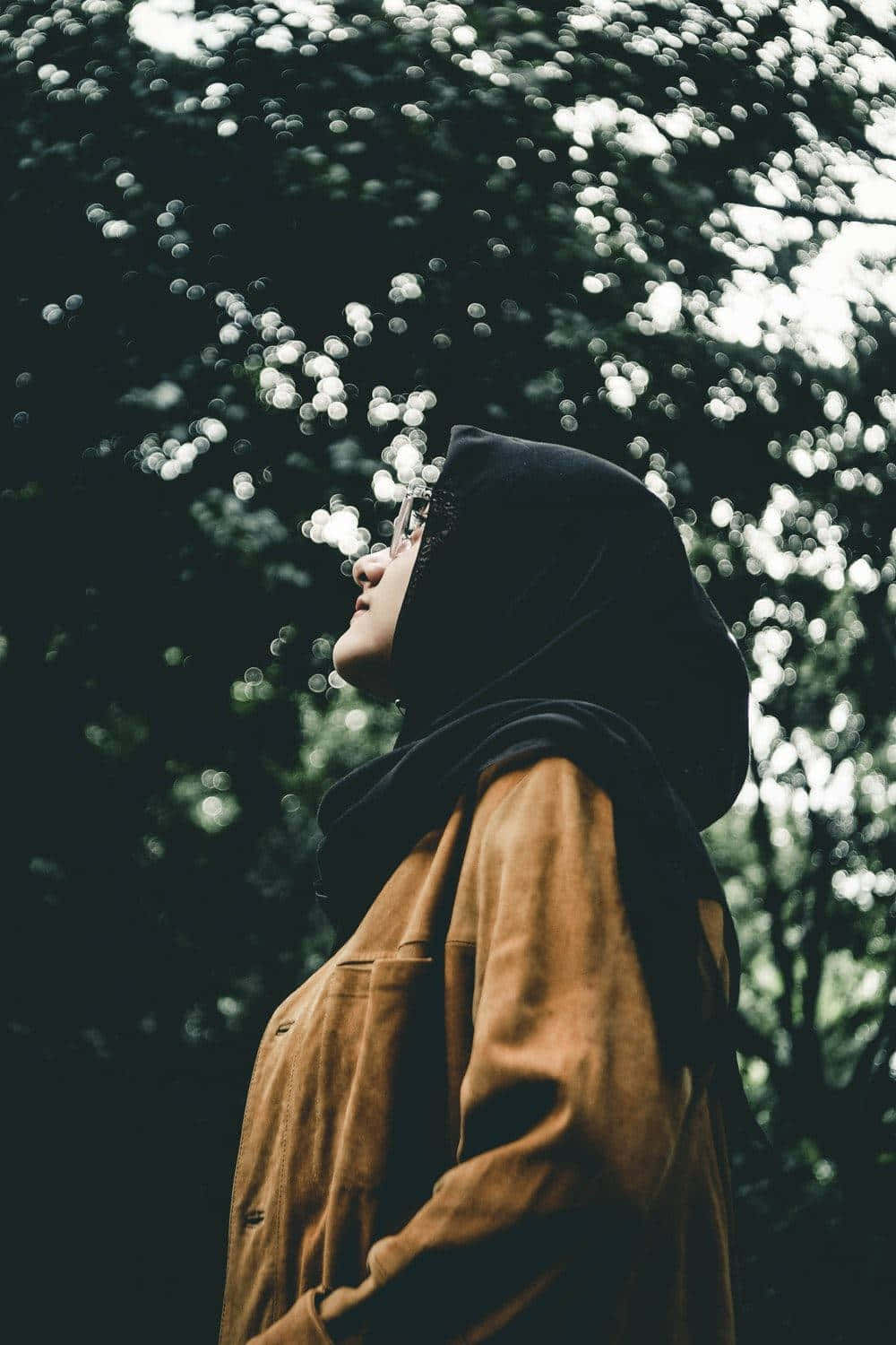 A Woman In A Hijab Standing In The Woods Background