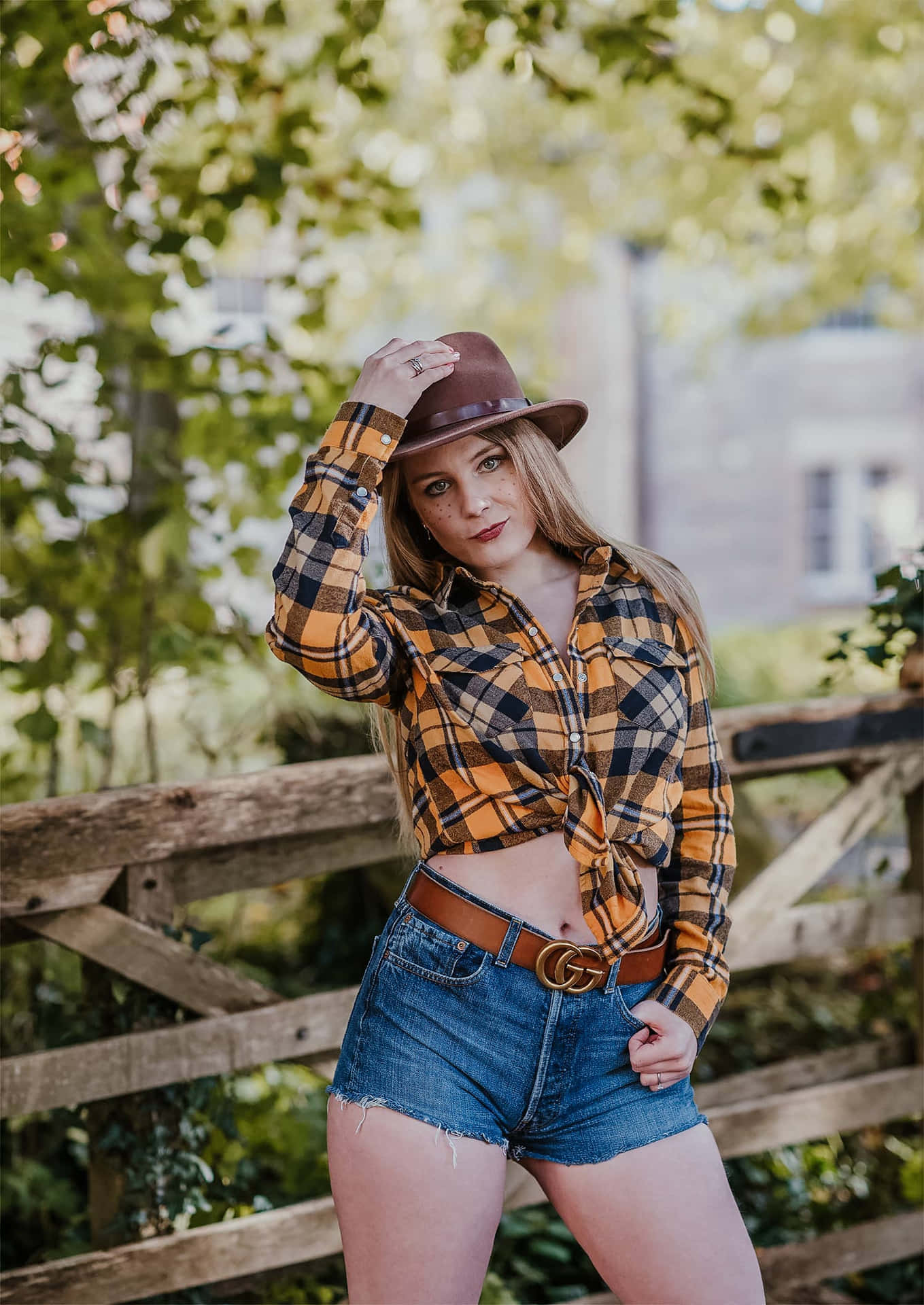 A Woman In A Plaid Shirt And Denim Shorts Posing Background