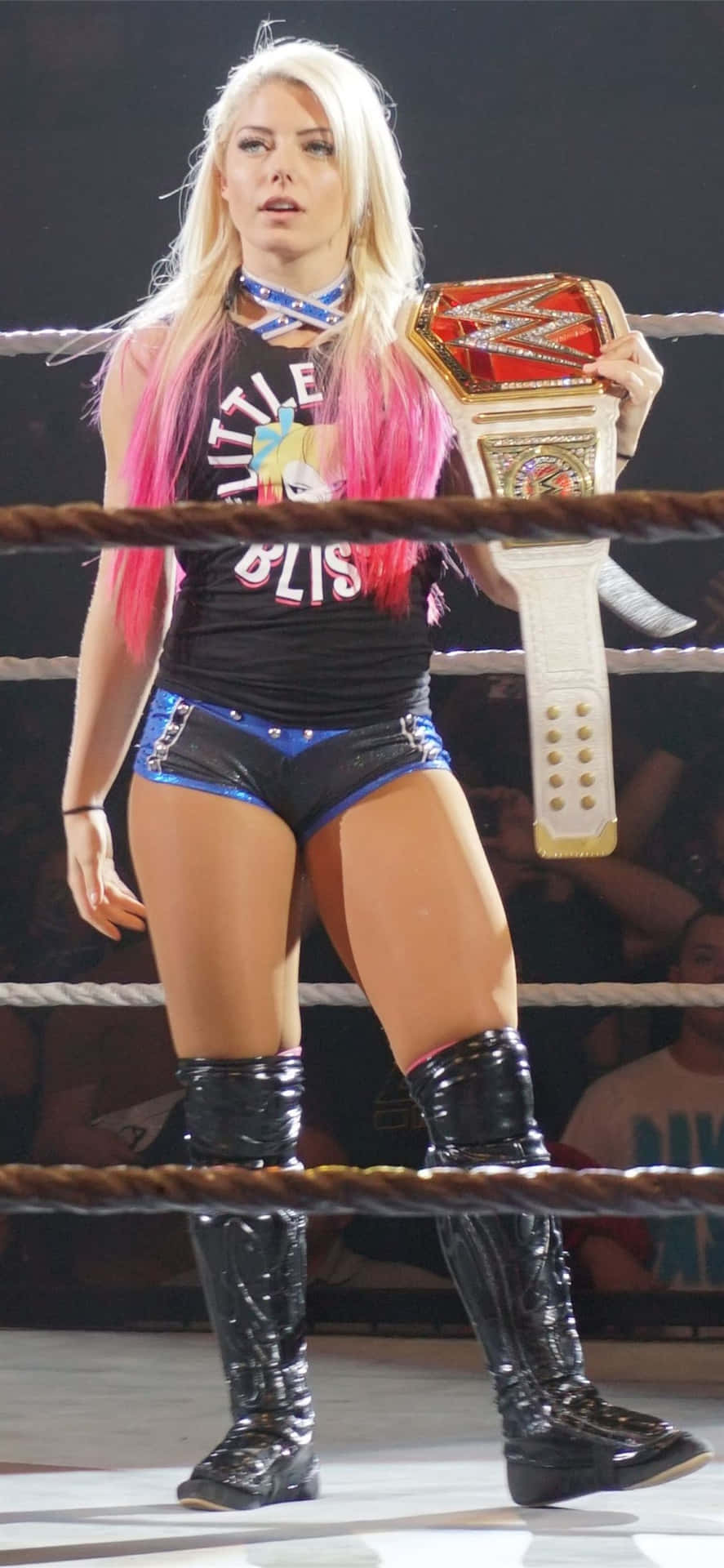 A Woman In A Wrestling Ring Holding A Belt