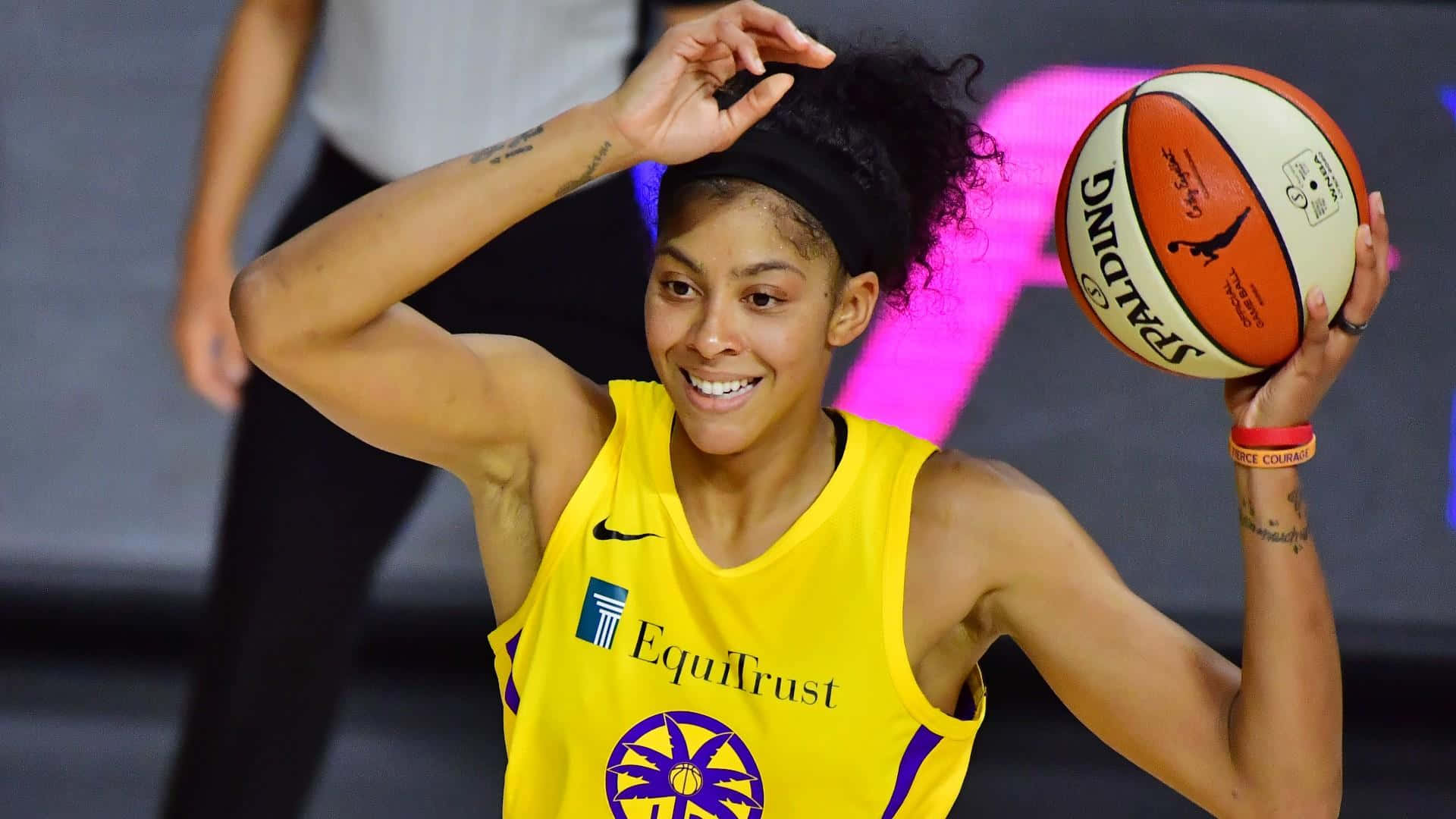 A Woman In A Yellow Uniform Holding A Basketball Background