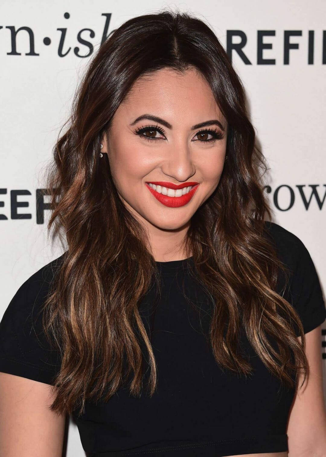 A Woman In Black With Red Lipstick Posing For A Photo Background