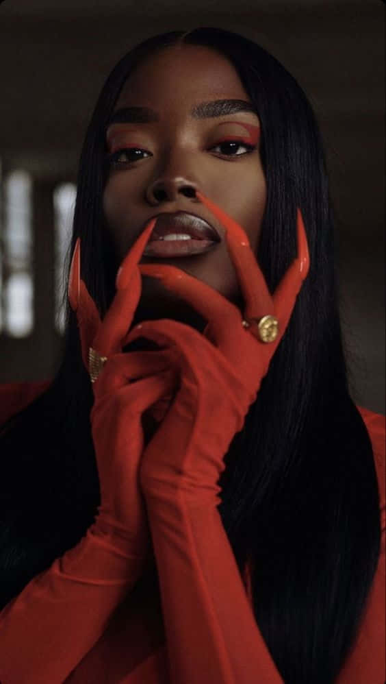 A Woman In Red With Gold Gloves Background