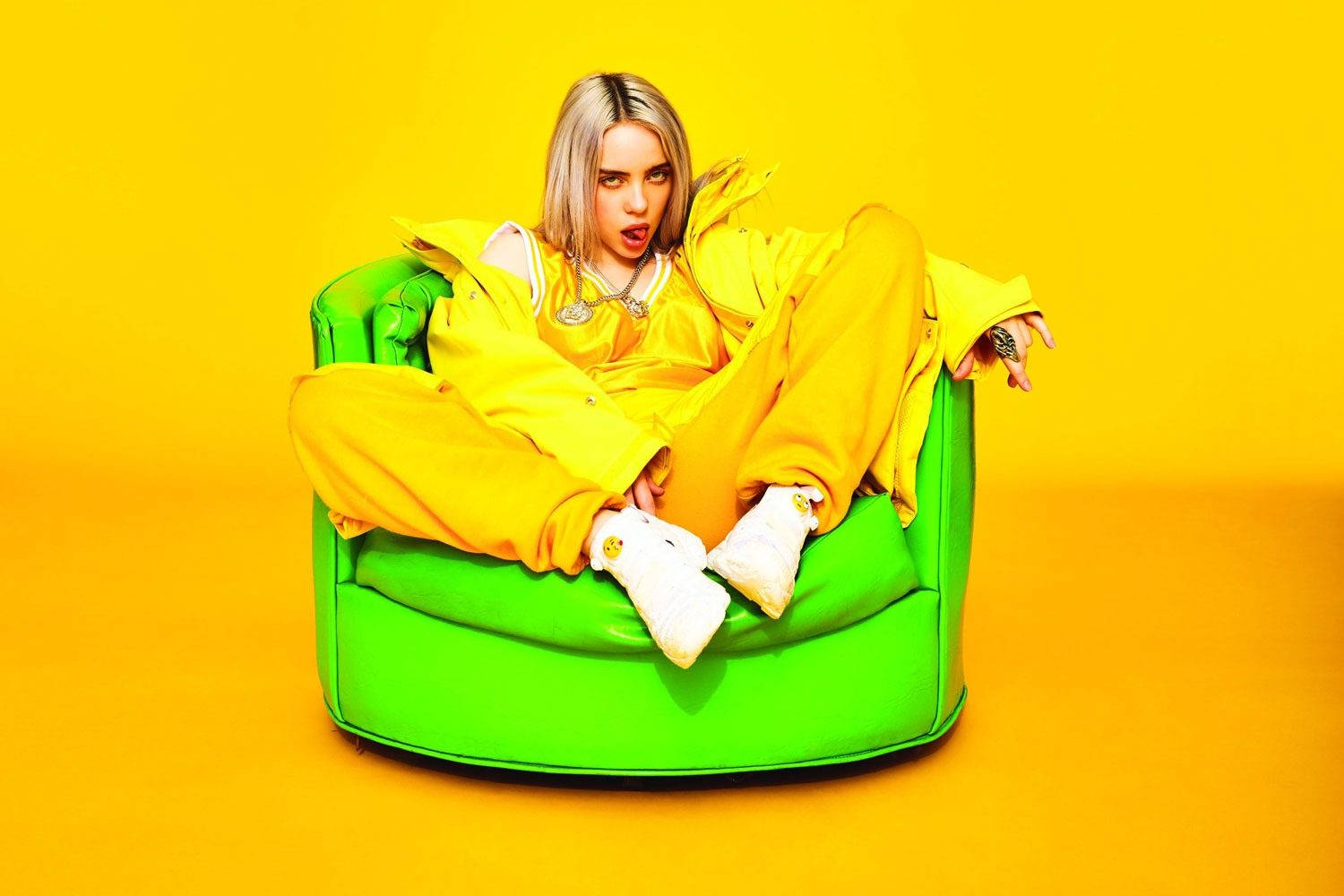 A Woman In Yellow Sitting On A Green Chair Background