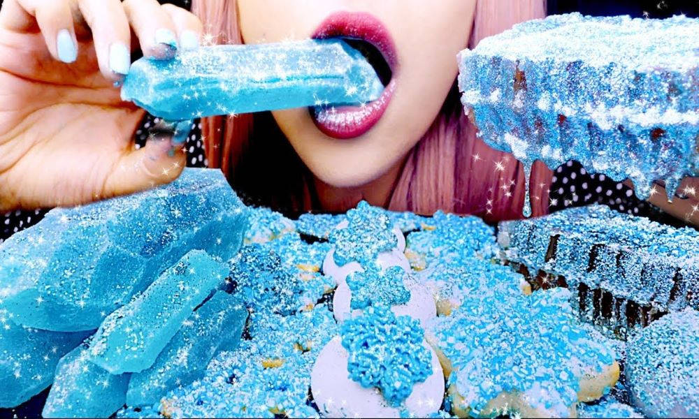 A Woman Is Eating Blue Ice Cream With A Blue Ice Cream Cone Background