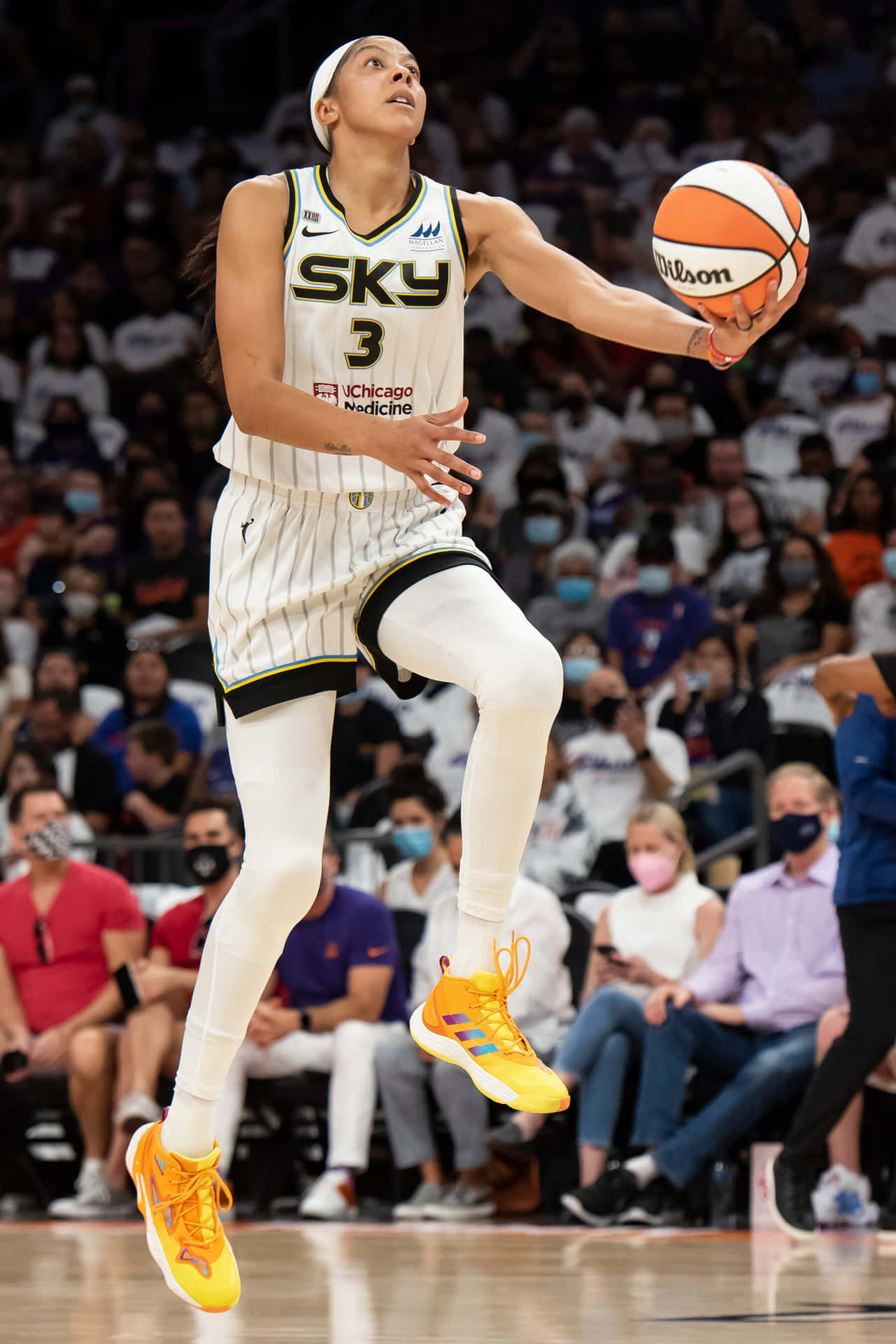 A Woman Is In The Air While Dribbling A Basketball