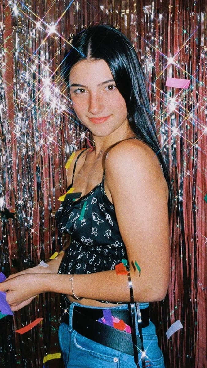 A Woman Is Standing In Front Of A Confetti Wall Background