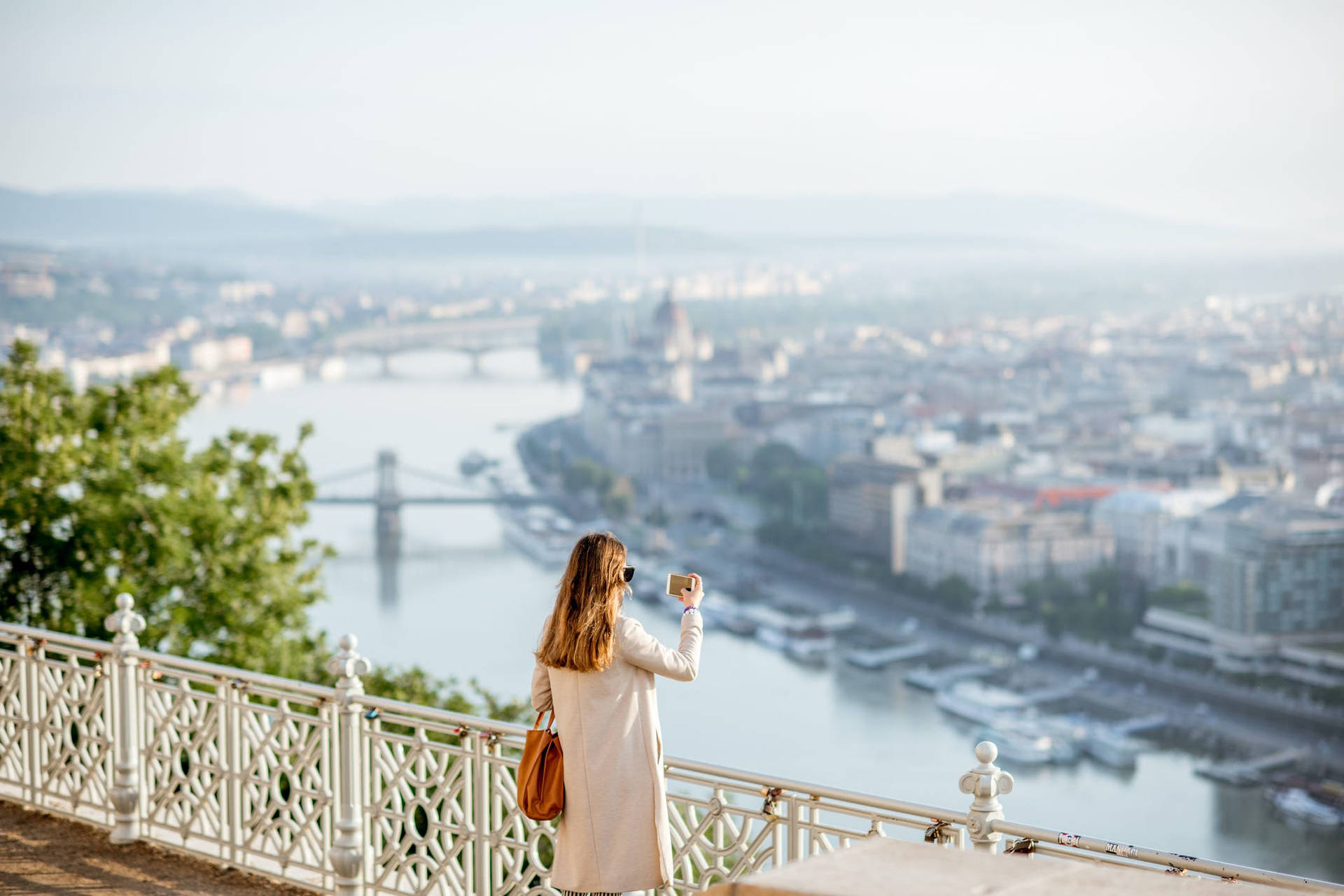 A Woman Is Standing On A Balcony Overlooking The River Danube