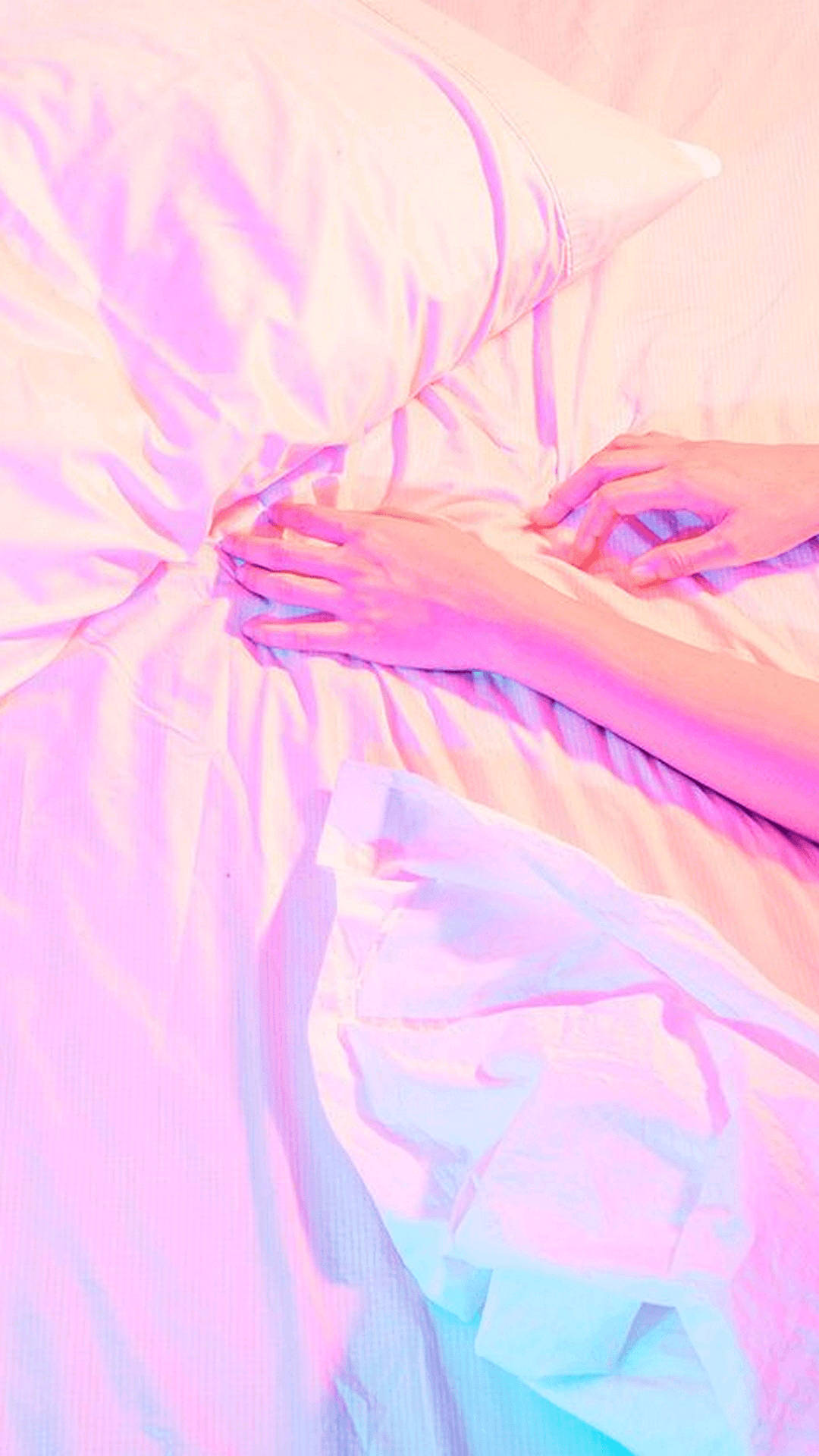 A Woman Laying On A Bed With A Pink Blanket Background