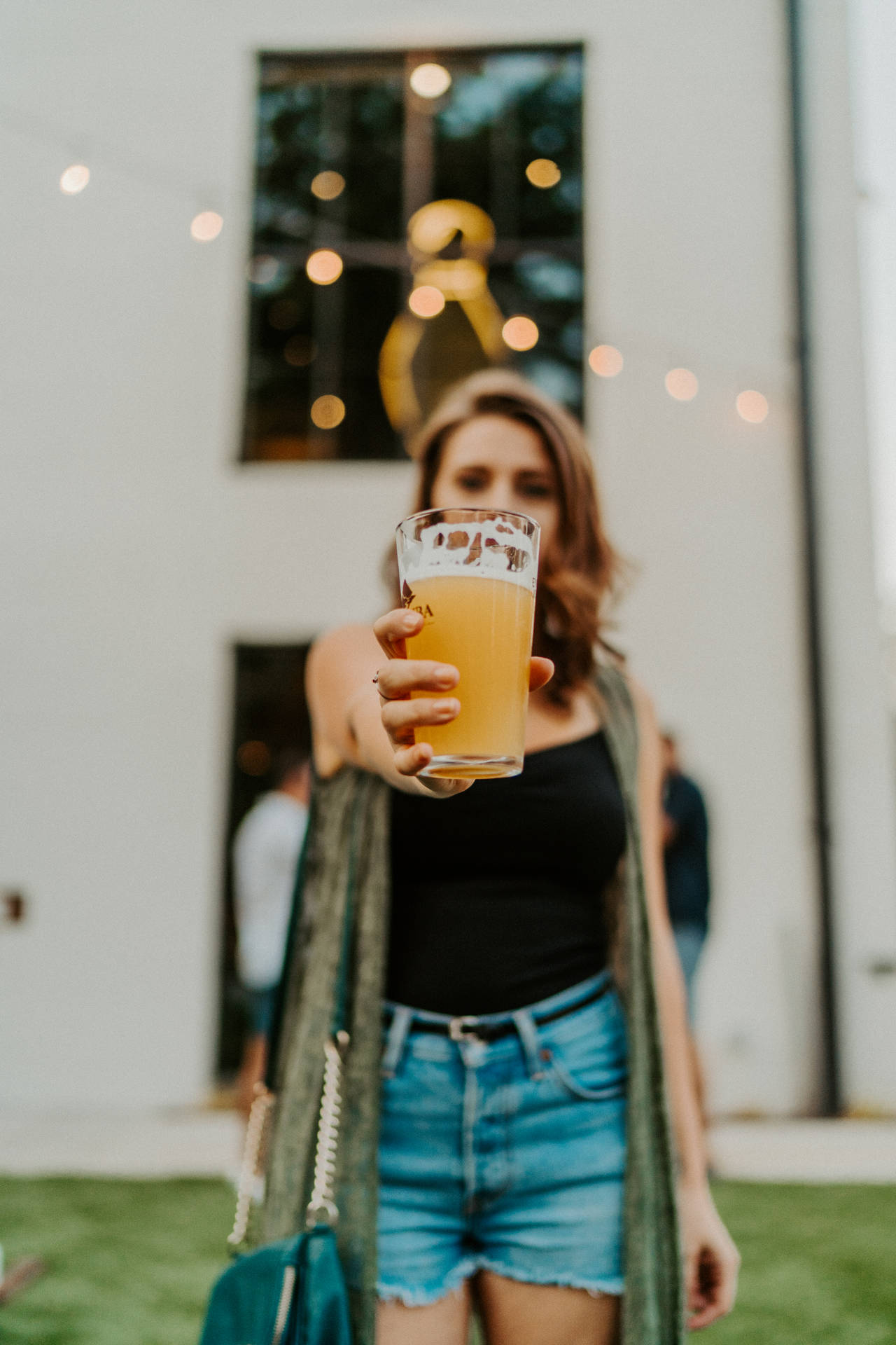 A Woman Raising A Beer In Appreciation