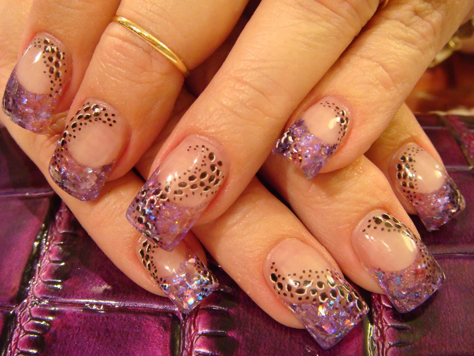 A Woman's Hand With Purple And Black Nail Designs Background