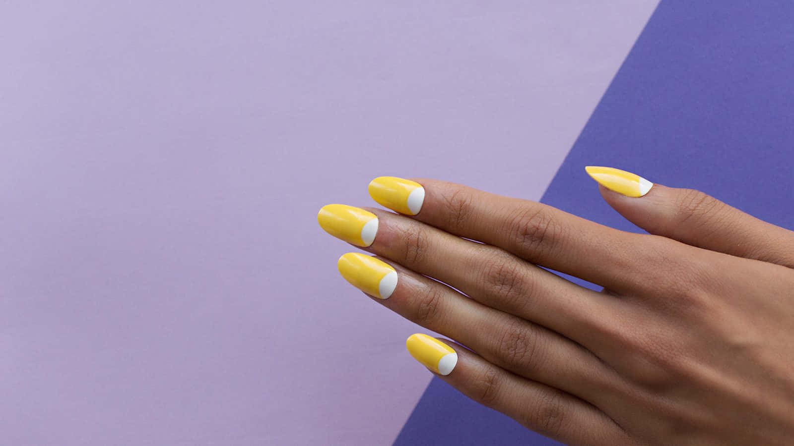 A Woman's Hand With Yellow And Purple Nails Background