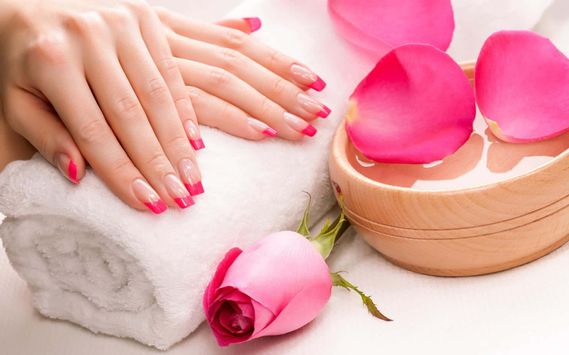 A Woman's Hands With Pink Nails And Roses On A Towel Background