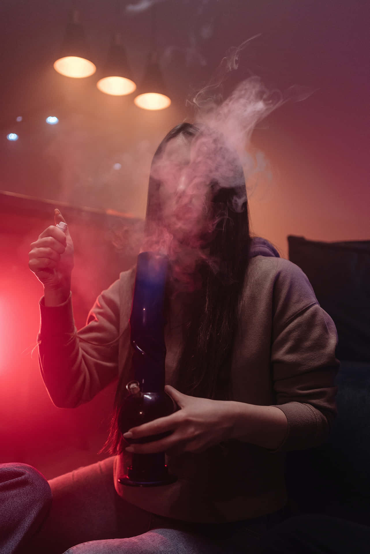 A Woman Smoking A Vaporizer In A Living Room Background