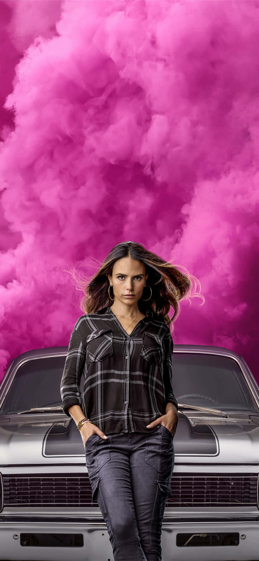 A Woman Standing Next To A Car With Pink Clouds Background