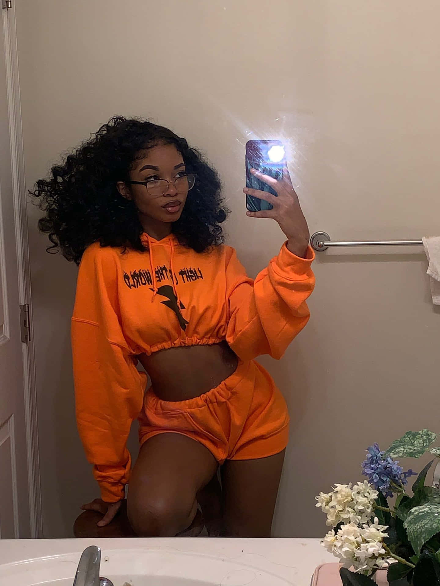 A Woman Taking A Selfie In An Orange Sweatsuit