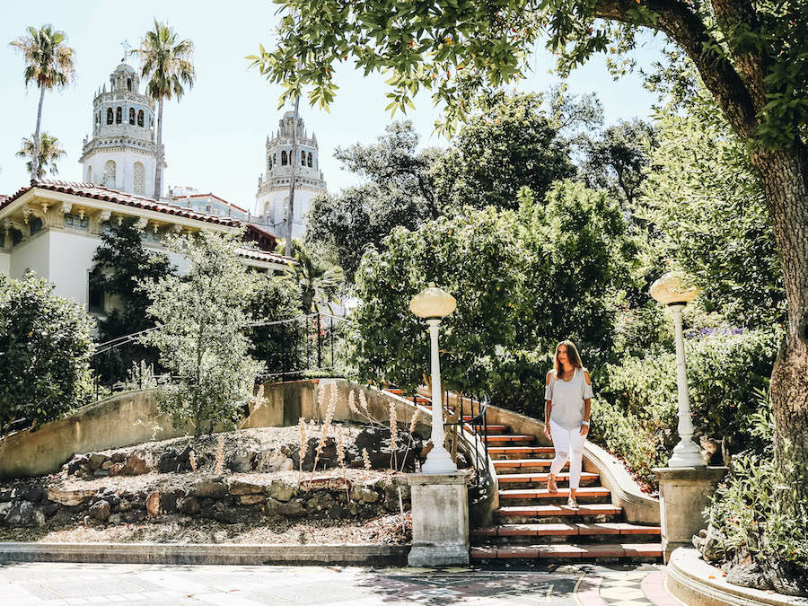 A Woman Walking Down The Stairs Of Hearst Castle Background