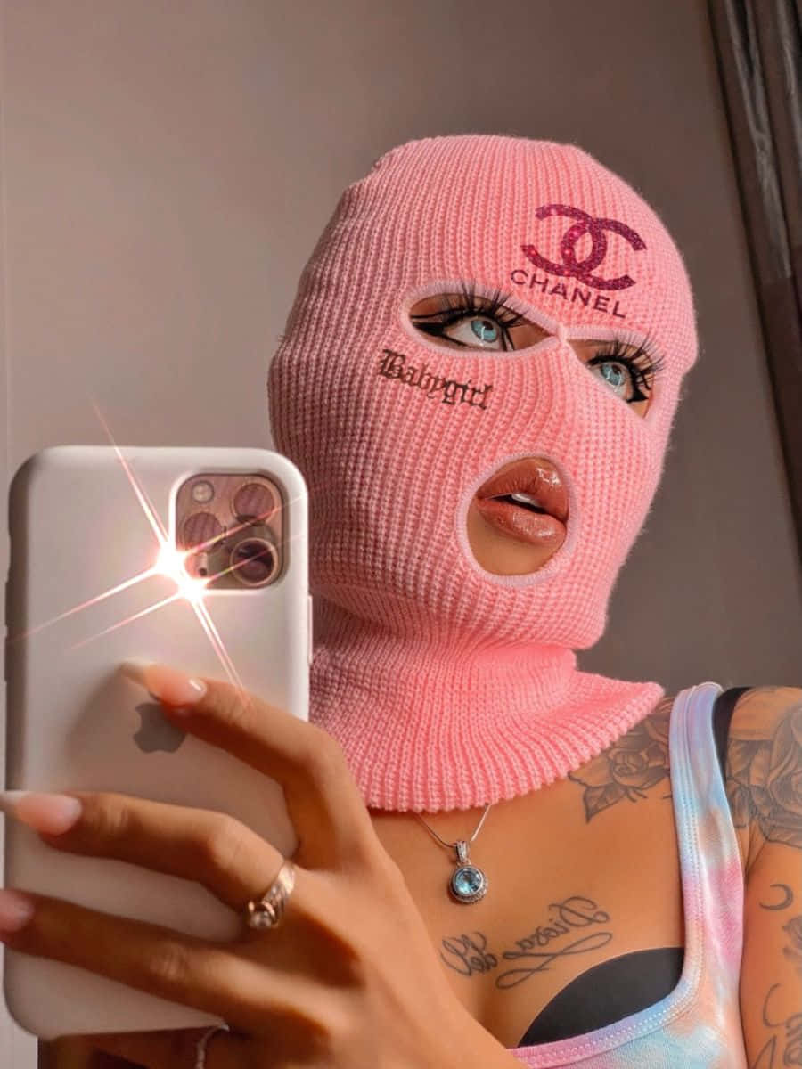 A Woman Wearing A Pink Knitted Mask Taking A Selfie