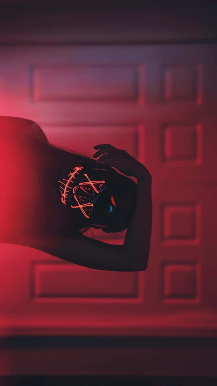 A Woman With A Red Neon Mask In Front Of A Door Background