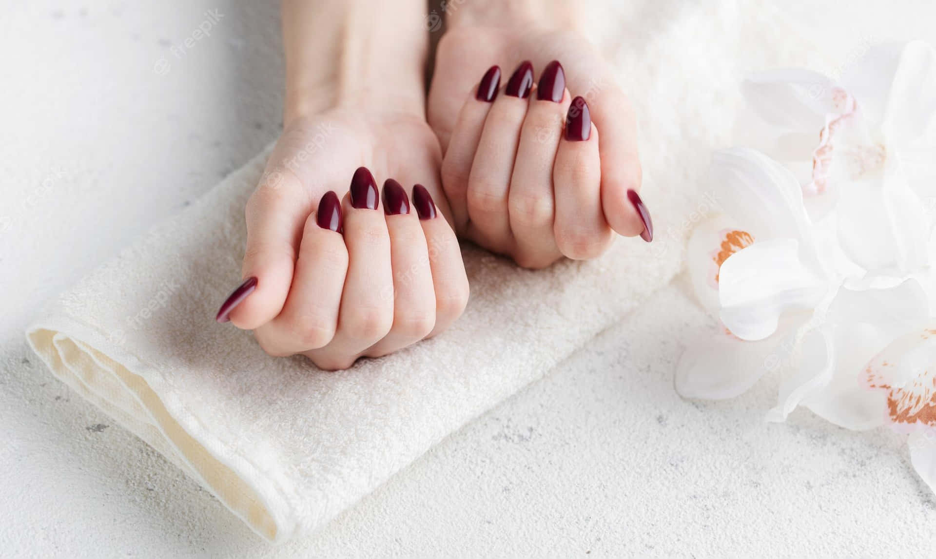 A Woman With Burgundy Nails Holding A Towel Background