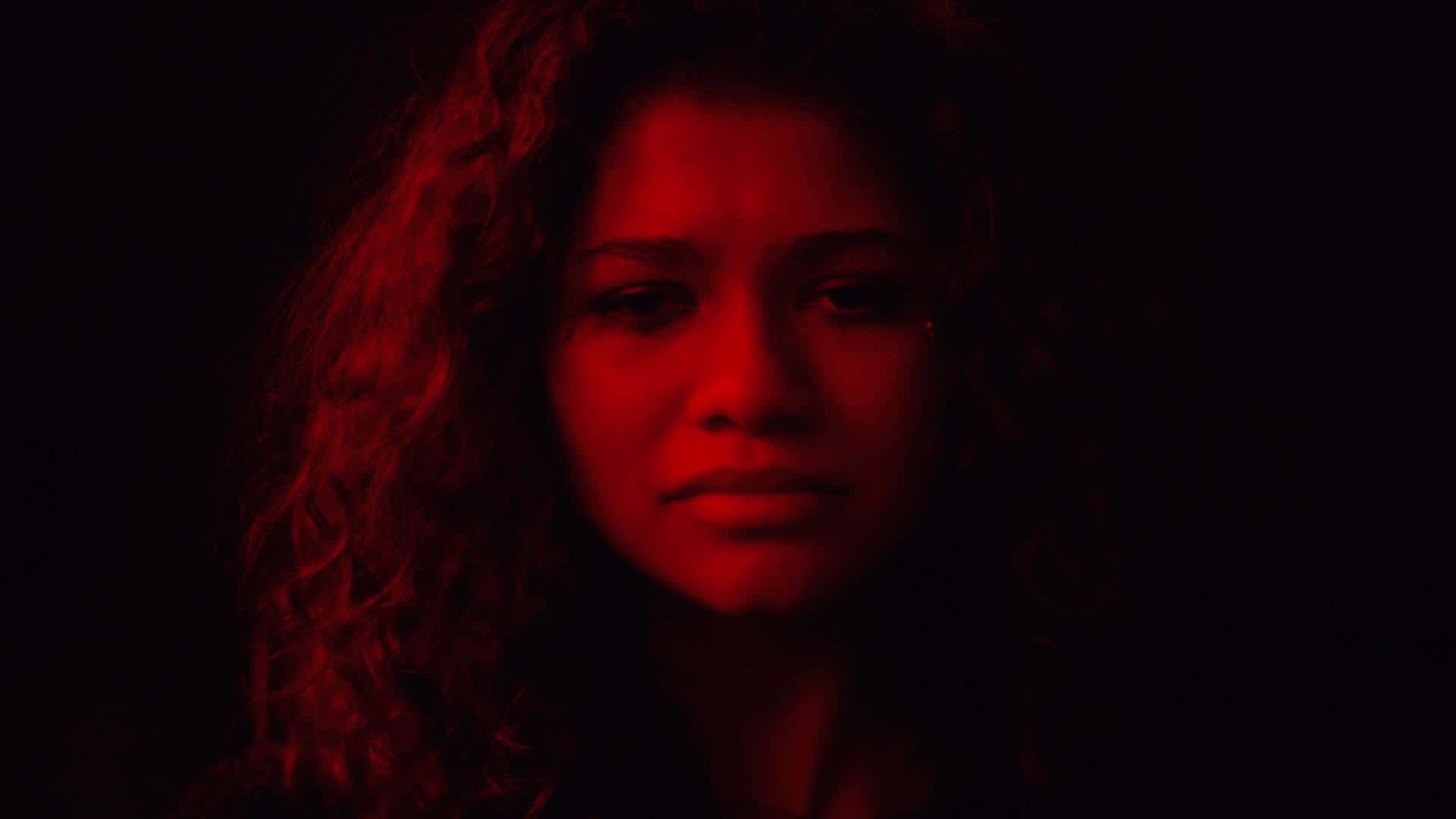 A Woman With Curly Hair In A Dark Room Background