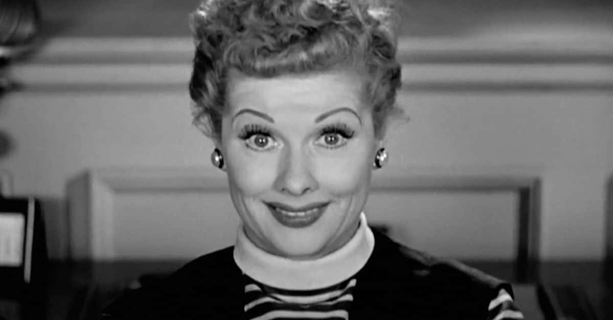 A Woman With Curly Hair Is Smiling In A Black And White Photo