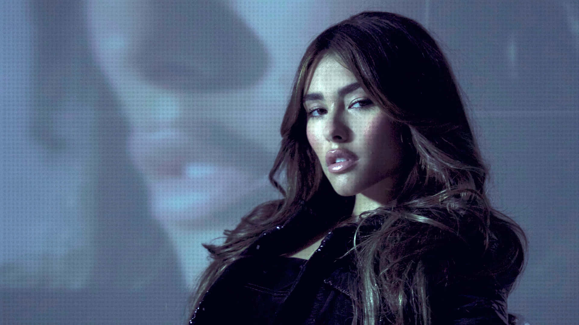 A Woman With Long Hair Is Posing In Front Of A Screen Background