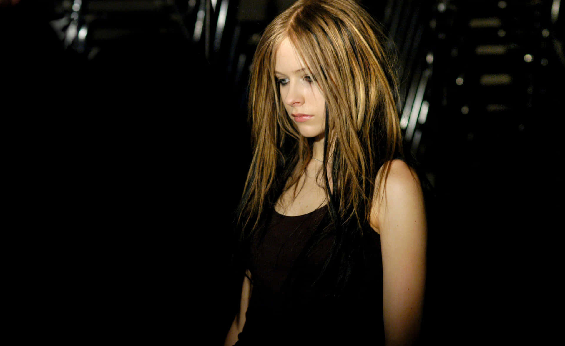 A Woman With Long Hair Standing In A Dark Room