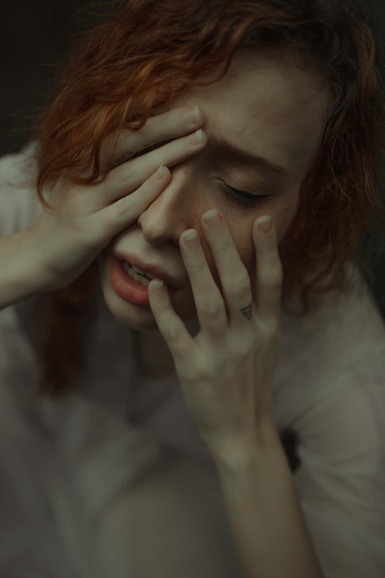 A Woman With Red Hair Covering Her Eyes Background