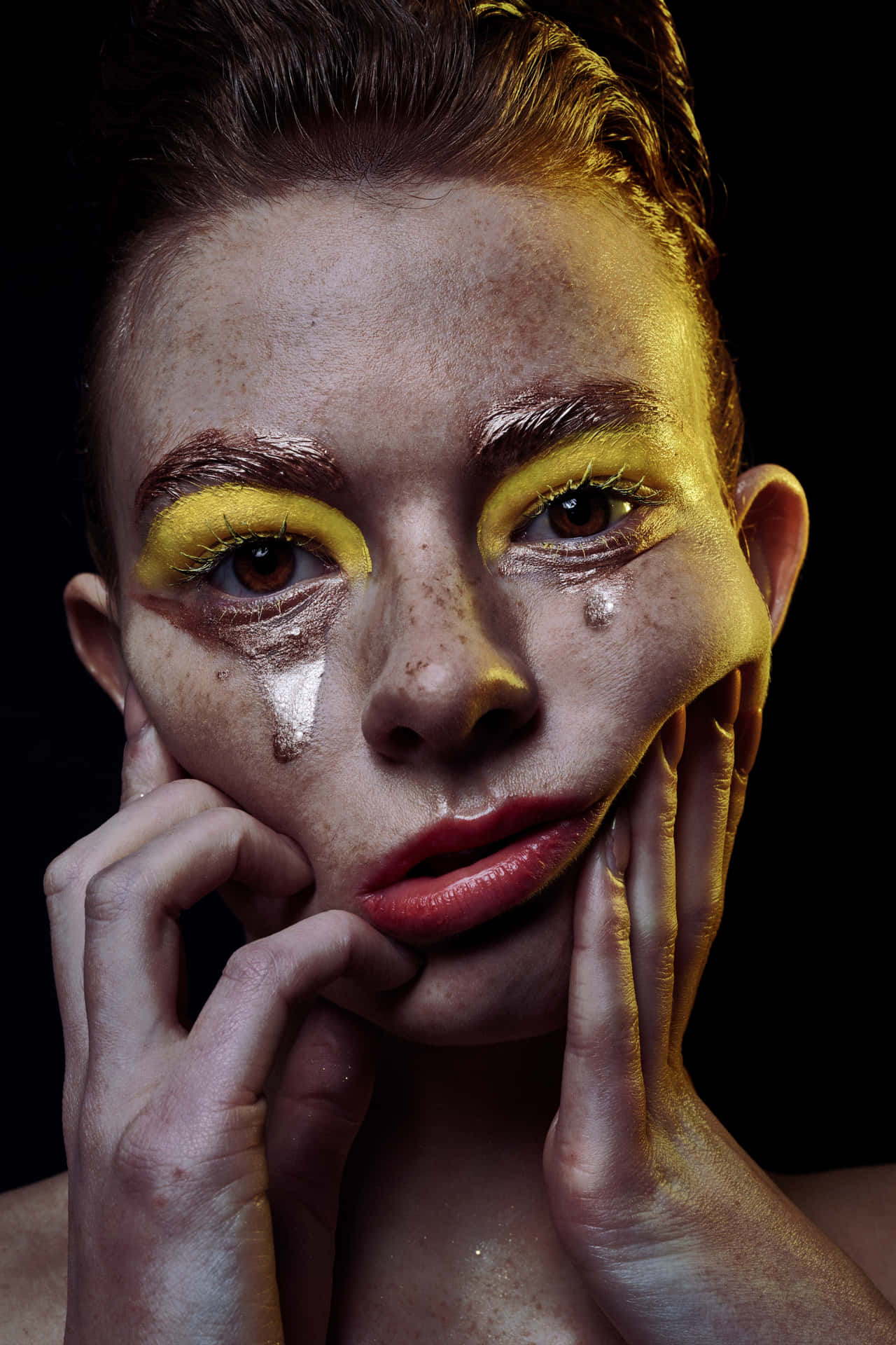 A Woman With Yellow Makeup And A Face Covered In Tears Background