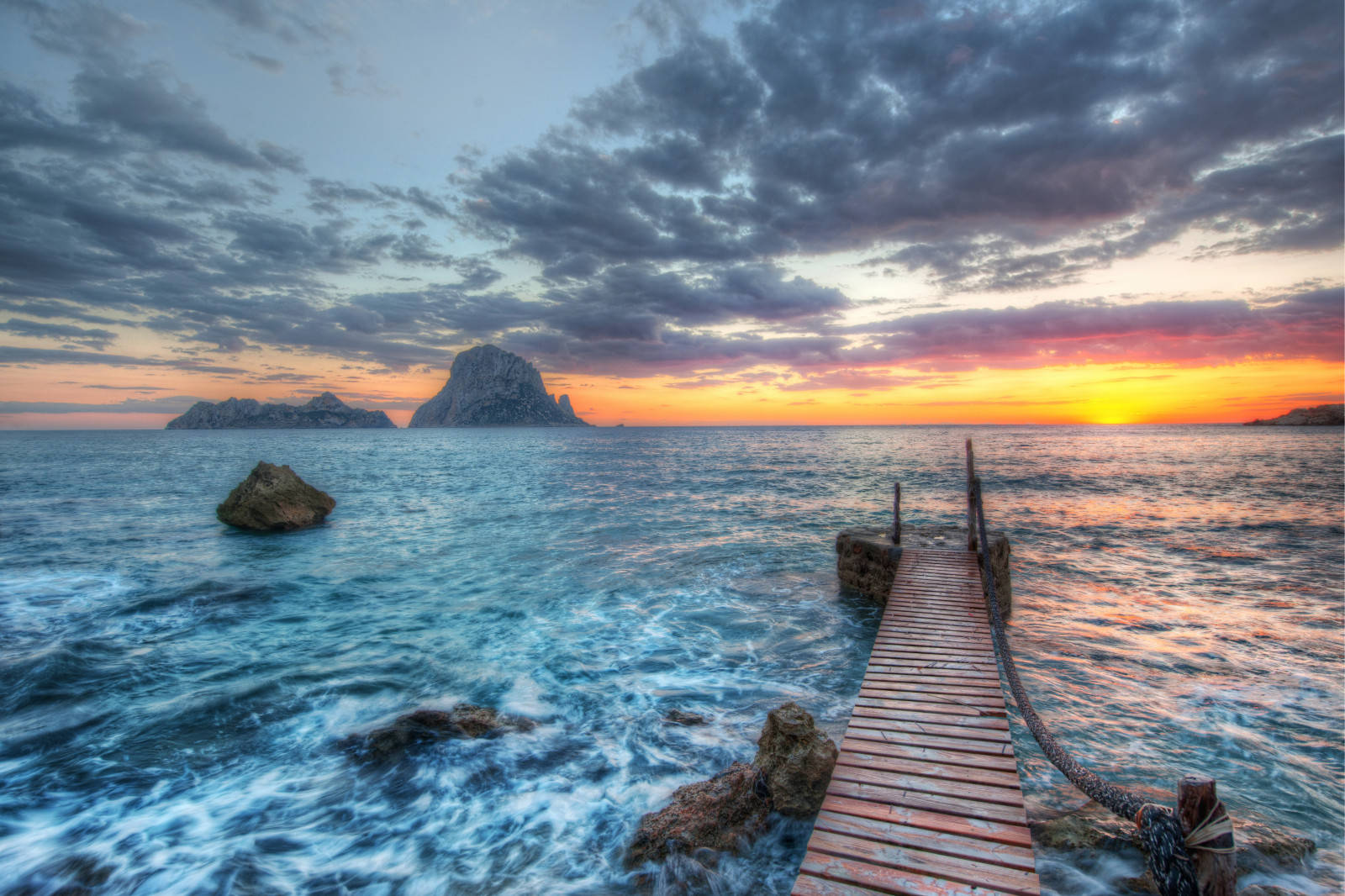 A Wooden Pier In The Ocean At Sunset Background