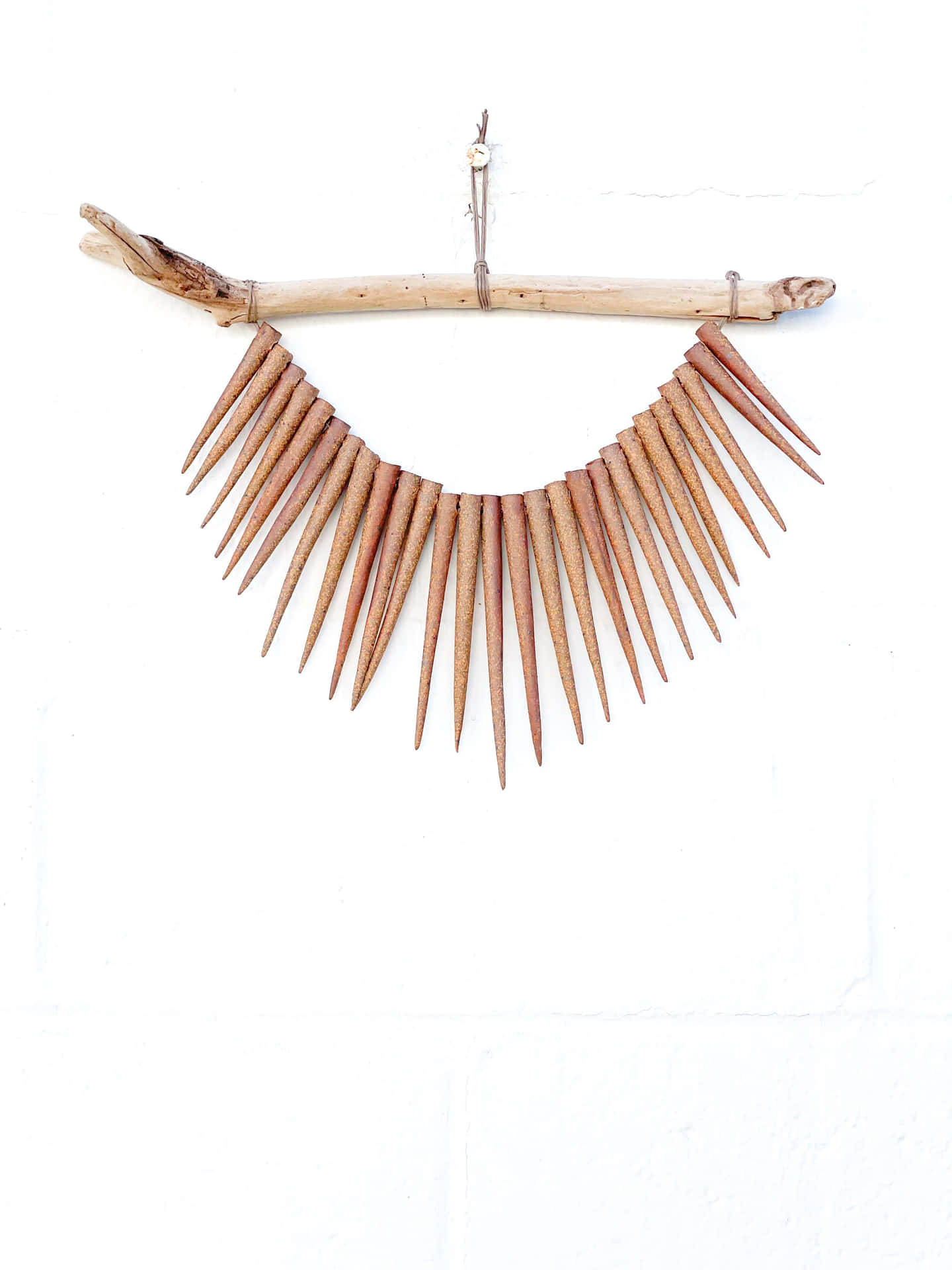 A Wooden Stick With Spikes Hanging From It Background