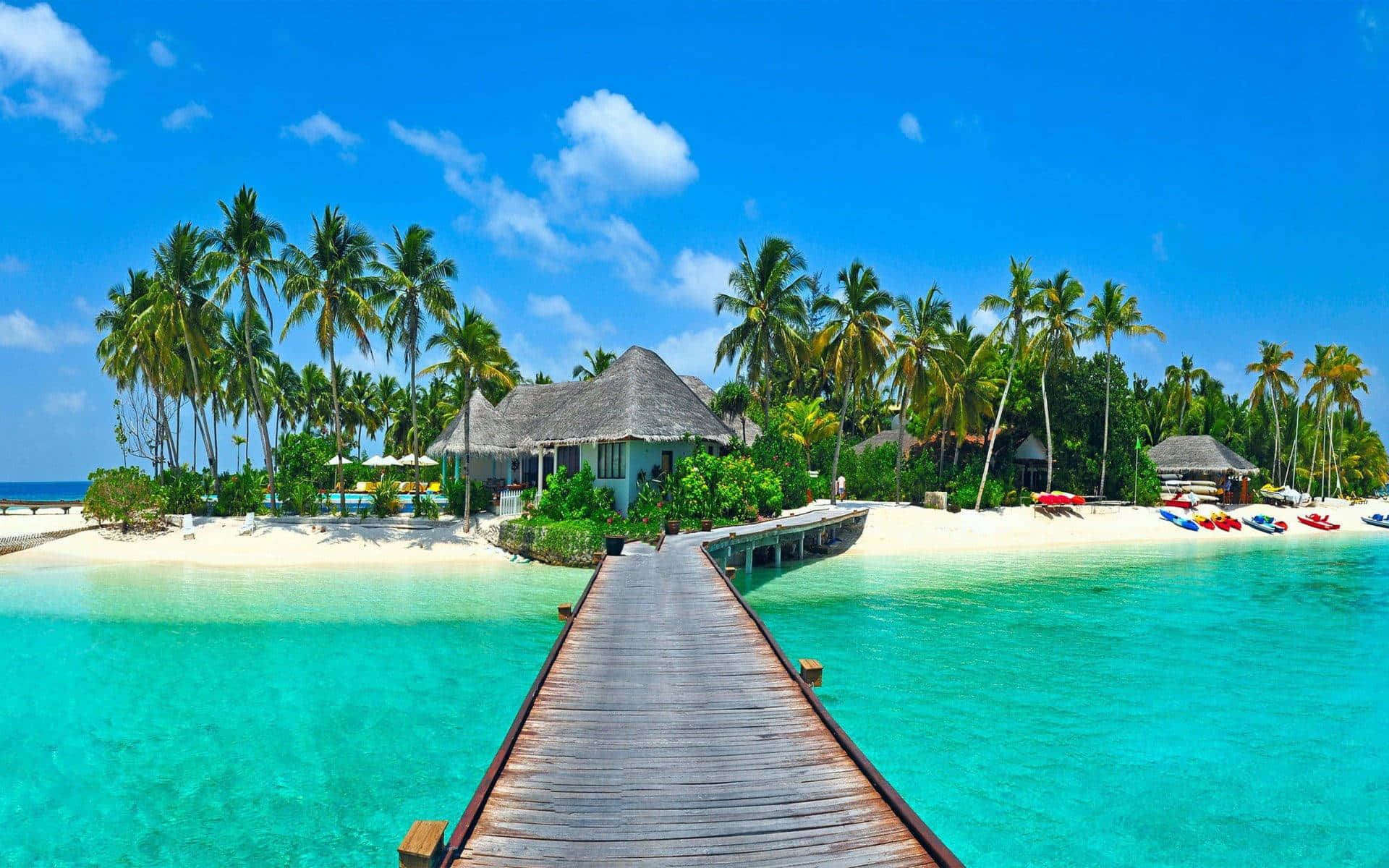 A Wooden Walkway Leading To An Island With Palm Trees Background