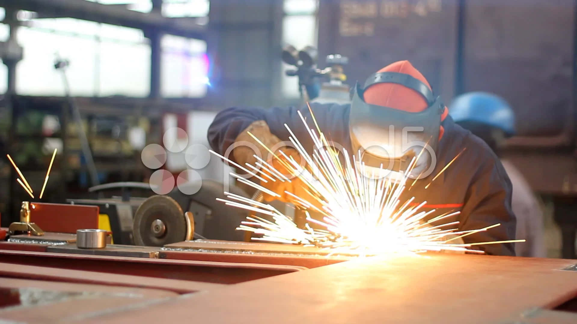 A Worker Is Welding Metal In A Factory Background