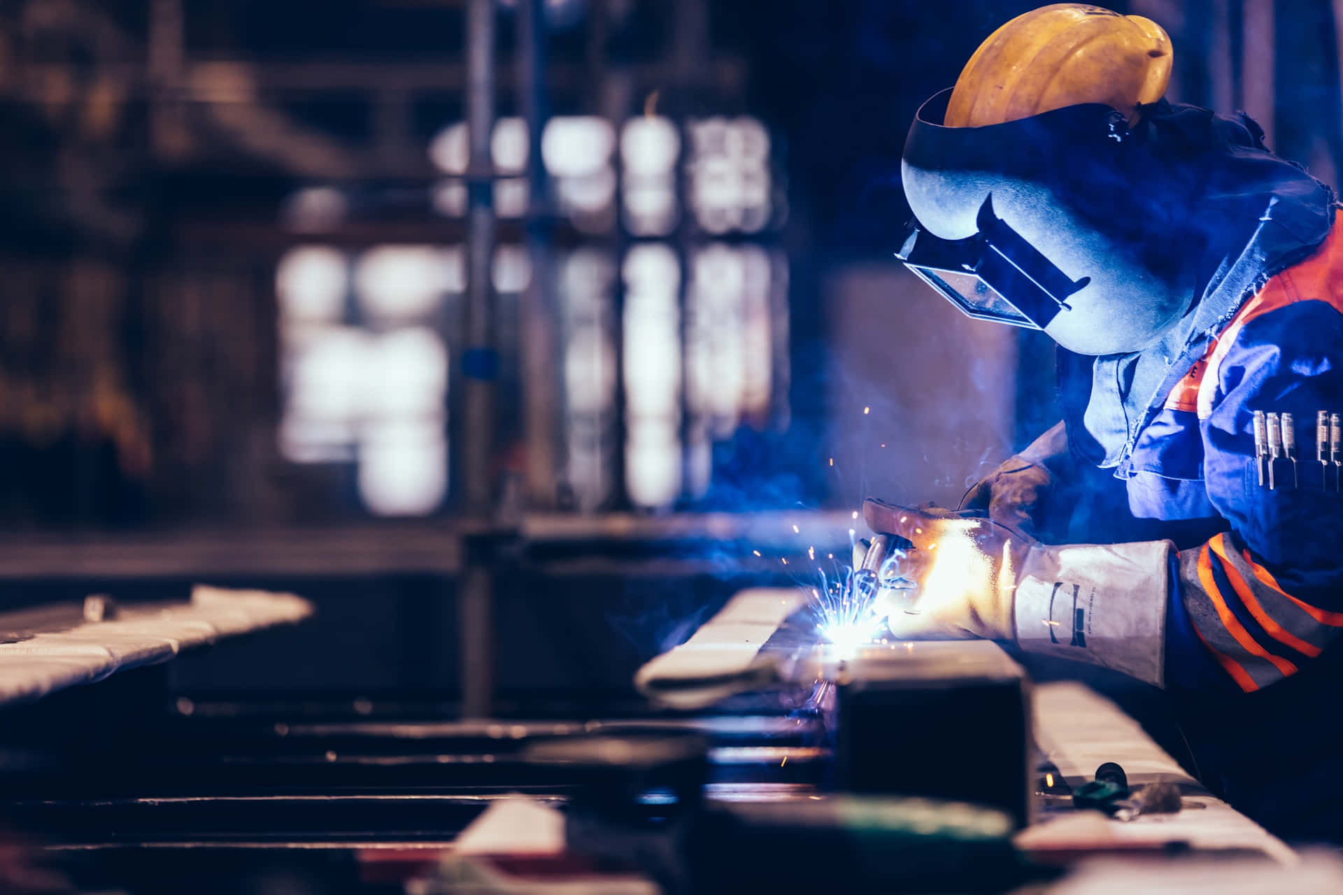 A Worker Welding Metal In A Factory