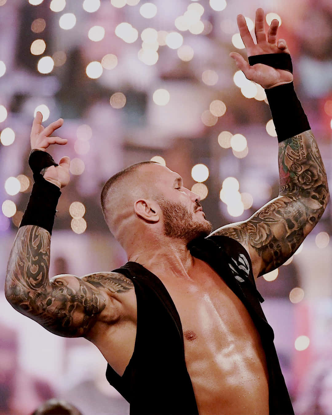 A Wrestler With Tattoos Is Holding His Hands Up