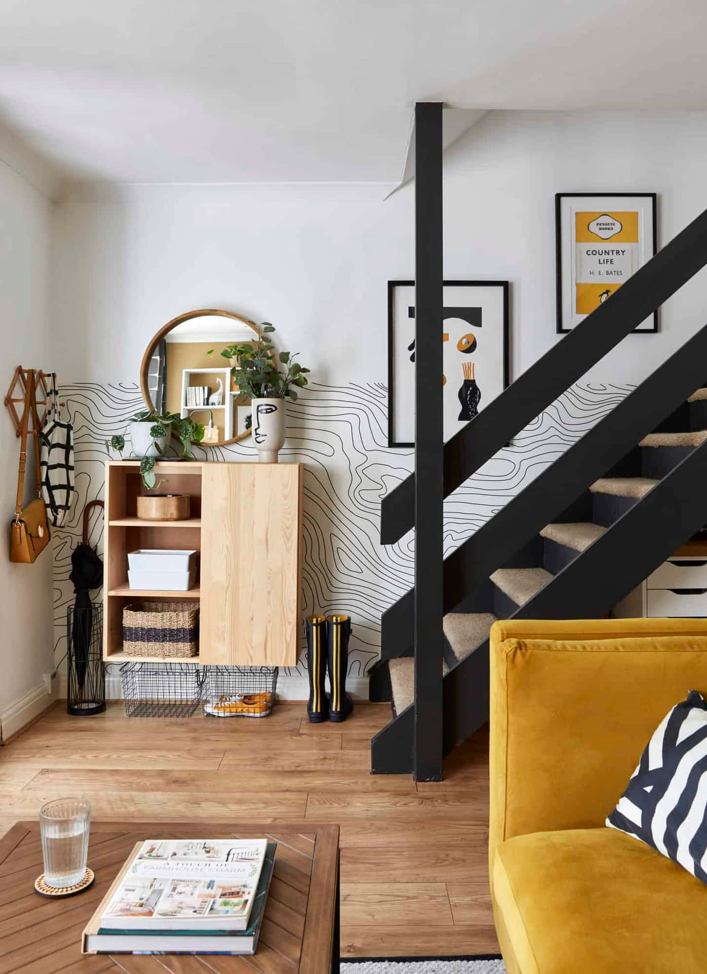A Yellow Couch And Black Stairs In A Living Room Background