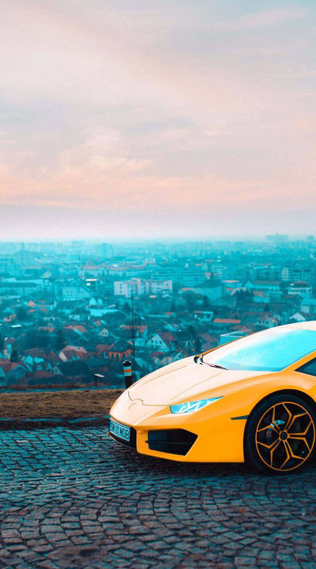 A Yellow Sports Car Parked On A Cobblestone Street Background