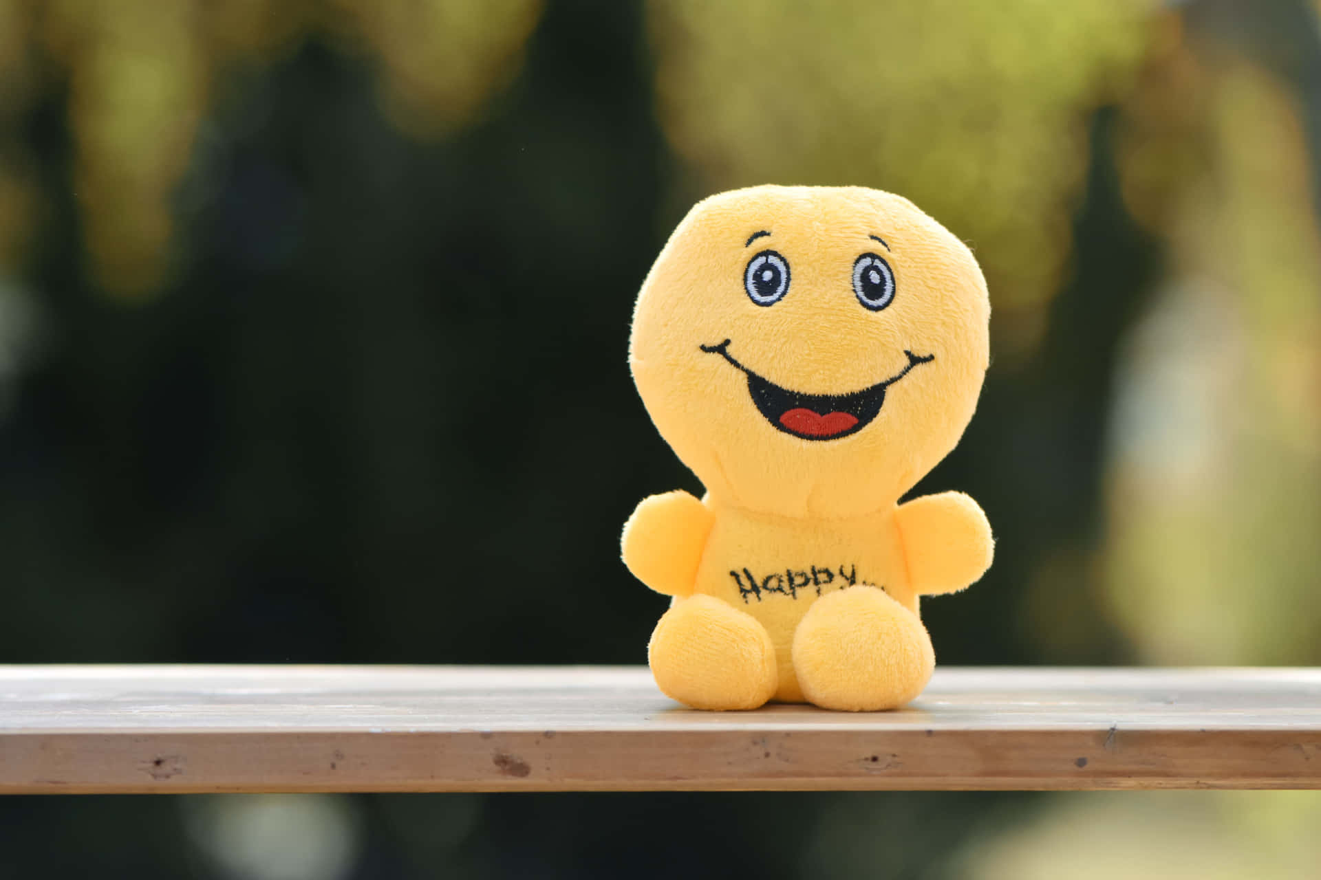 A Yellow Stuffed Animal With The Word Happy On It