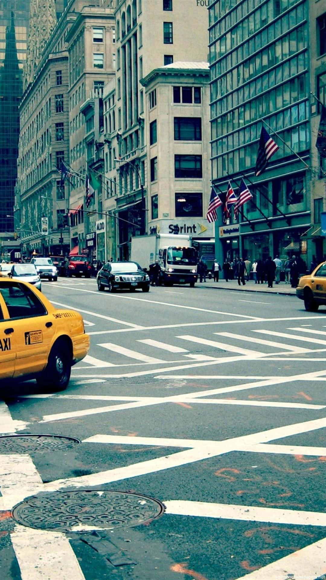 A Yellow Taxi Cab Is Driving Down A Street Background
