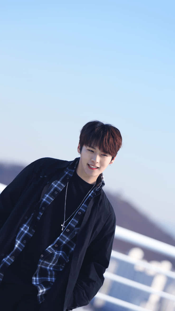 A Young Man In A Black Jacket And Plaid Shirt Background