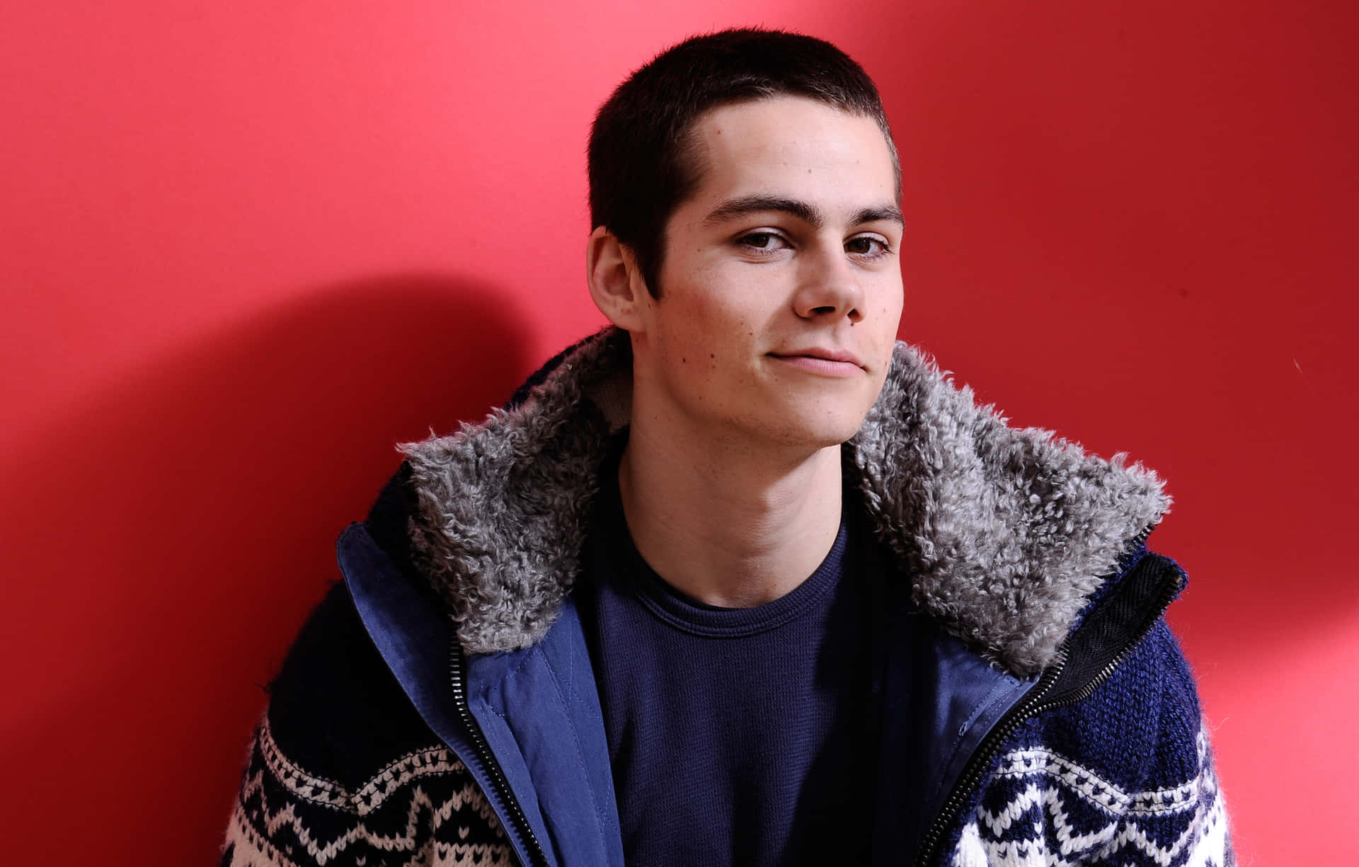 A Young Man In A Blue Jacket And Sweater Background