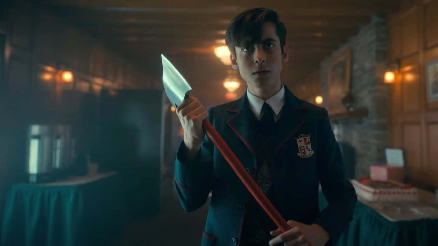 A Young Man In A School Uniform Holding A Large Knife Background