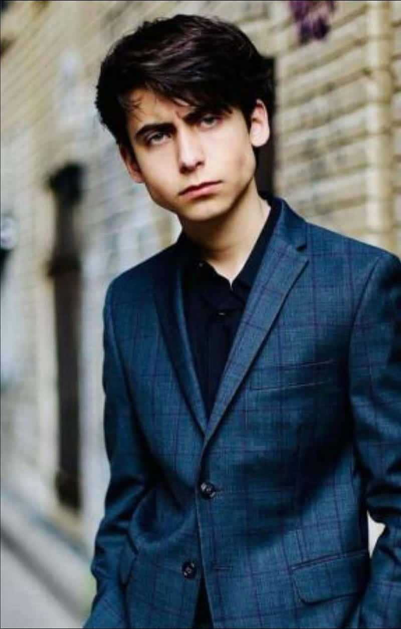 A Young Man In A Suit Is Posing For A Picture Background