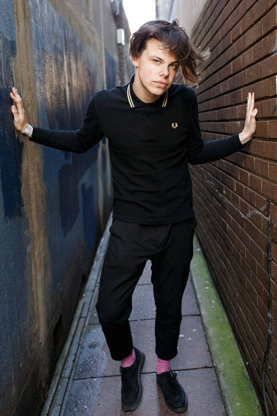 A Young Man In Black Standing In A Alleyway Background