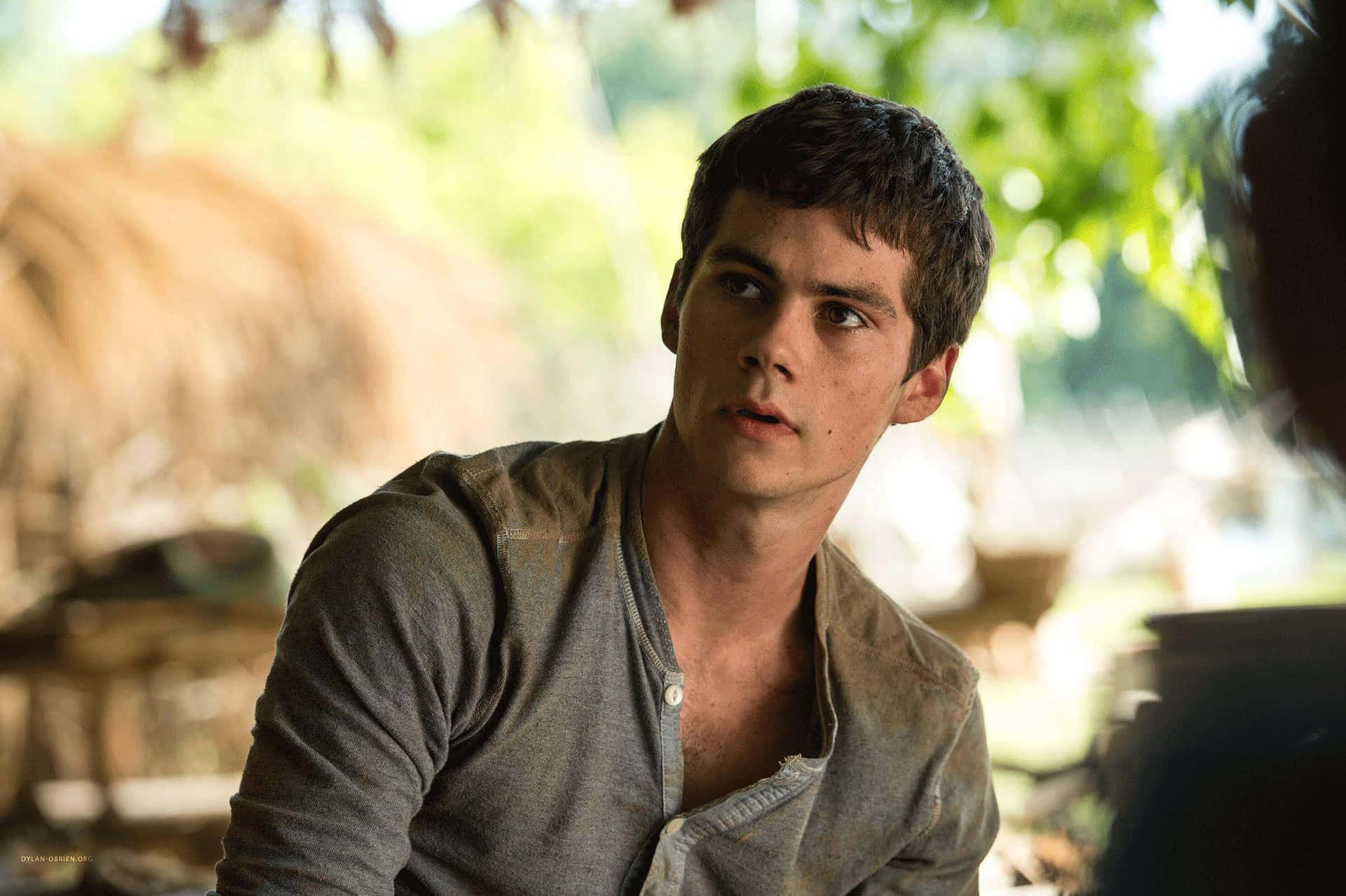 A Young Man Is Sitting In A Group Of People Background