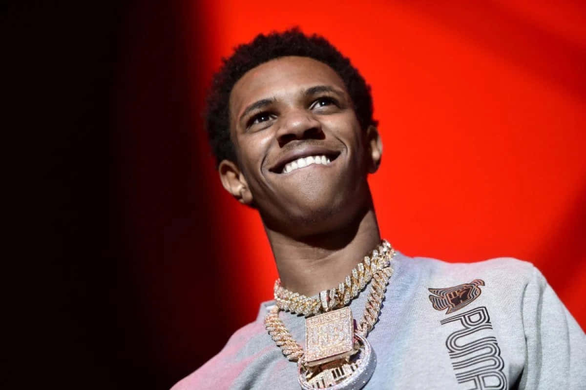 A Young Man Is Smiling While Wearing A Necklace Background