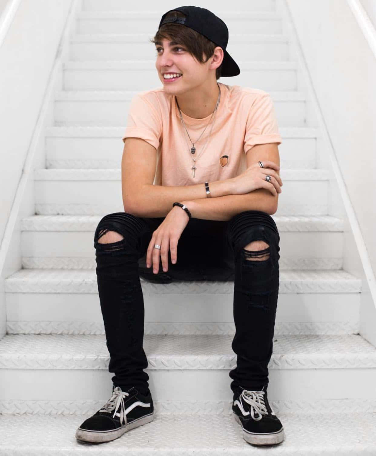 A Young Man Sitting On A Set Of Stairs Background